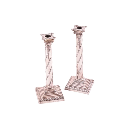 330 - A pair of Victorian silver Corinthain column candlesticks; the slightly tapering columns with diagon... 