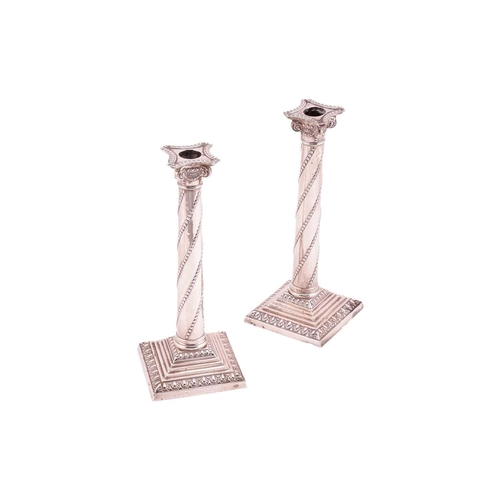 330 - A pair of Victorian silver Corinthain column candlesticks; the slightly tapering columns with diagon... 