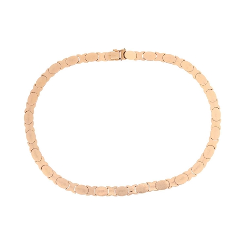 51 - A two-toned link necklace of modular design, comprising a series of stylised oval and cross hinged l... 