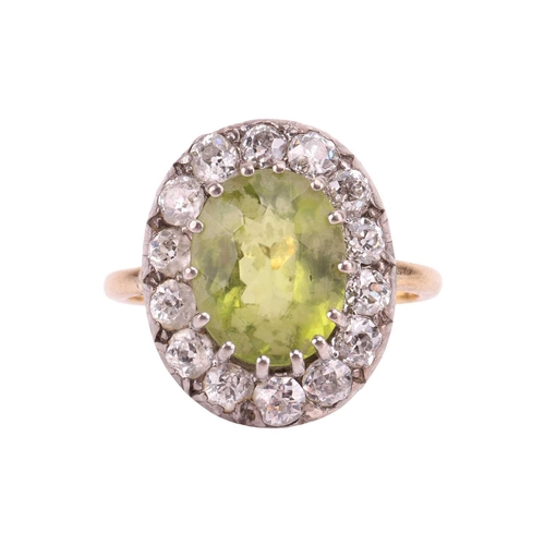 65 - An Edwardian peridot and diamond entourage ring, centred with an oval-cut peridot of bright yellowis... 