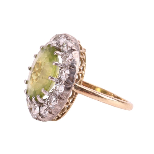 65 - An Edwardian peridot and diamond entourage ring, centred with an oval-cut peridot of bright yellowis... 