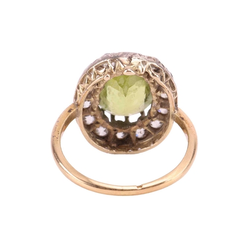 65 - An Edwardian peridot and diamond entourage ring, centred with an oval-cut peridot of bright yellowis... 