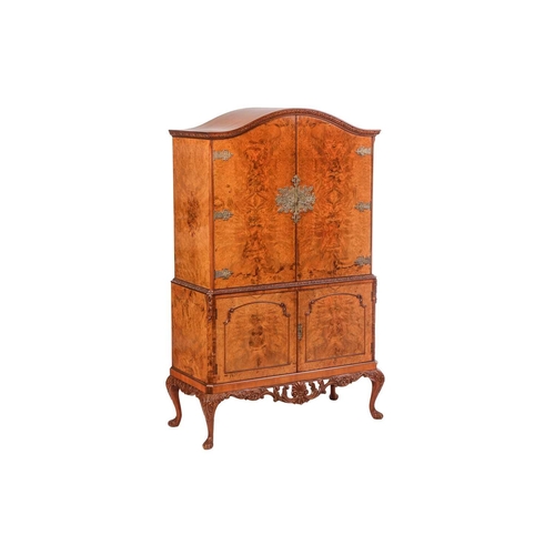 100 - A mid-20th century burr walnut four-door cocktail cabinet, with mirrored and shelved interior to the... 