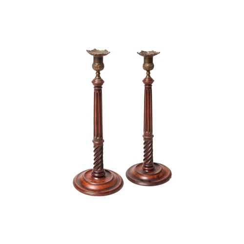 112 - A pair of George III mahogany, turned mahogany and brass table candlesticks, with detachable petalle... 