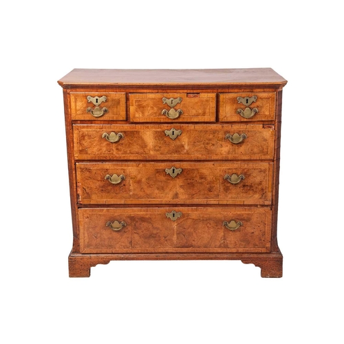 87 - A George I walnut chest, with three short and three long graduated drawers, fluted corners and brack... 