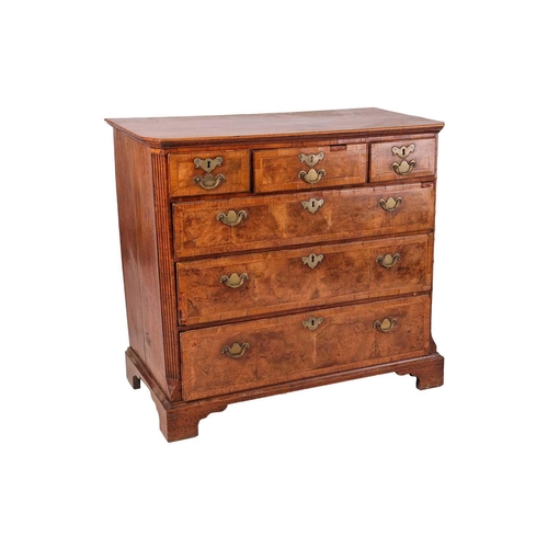 87 - A George I walnut chest, with three short and three long graduated drawers, fluted corners and brack... 