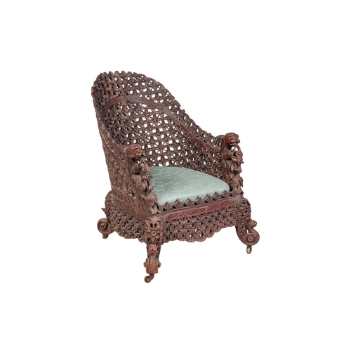 88 - An Anglo-Indian carved hardwood armchair, late 19th century, with lattice work back and front rail, ... 