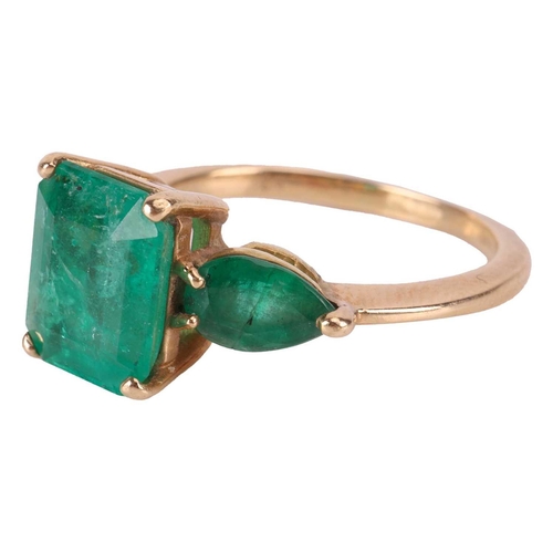 14 - An emerald trilogy ring, centred with a step-cut emerald with canted corners of 9.8 x 8.1 x 5.2 mm, ... 