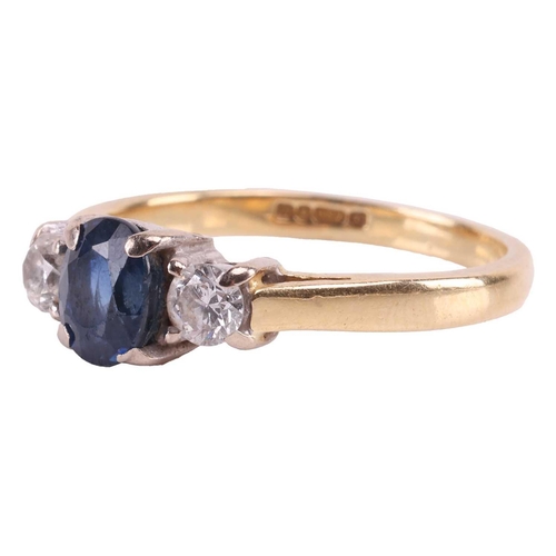 31 - A sapphire and diamond three-stone ring, centred with a claw-set oval-cut sapphire of deep blue colo... 