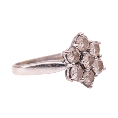 38 - A diamond-set floral cluster ring in 18ct white gold, claw-set with seven round brilliant diamonds, ... 