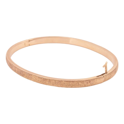 56 - De Beers - a hinged bangle in 18ct yellow gold, featuring a polki diamond gypsy-set to the front, th... 