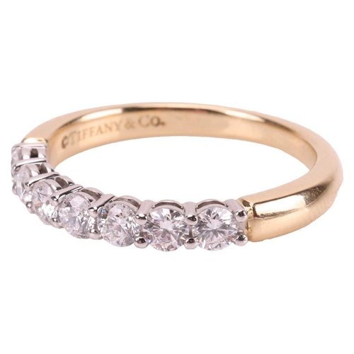 59 - Tiffany & Co - a diamond half-eternity ring, featuring seven round brilliant diamonds with an estima... 