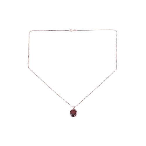 62 - A garnet pendant on chain, the oval mixed-cut garnet set in a white metal mount marked '585', measur... 