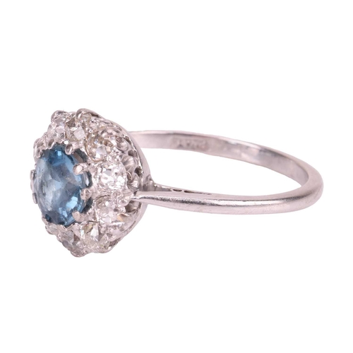 88 - An aquamarine and diamond cluster ring, centred with a circular-cut aquamarine in deep blue colour, ... 