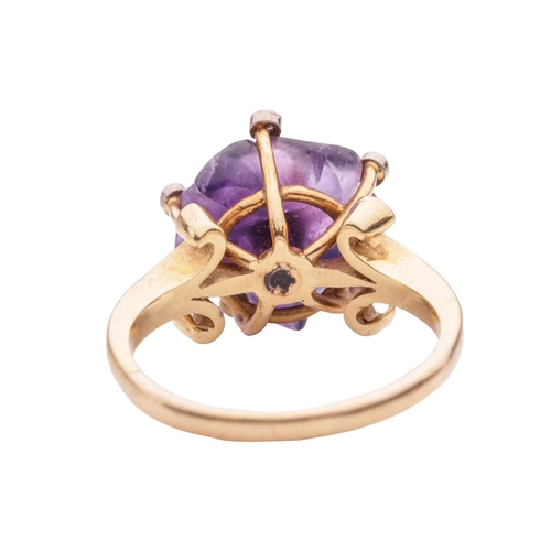 96 - A carved amethyst and diamond dress ring, with a carved amethyst in the form of a flowerhead, set wi... 