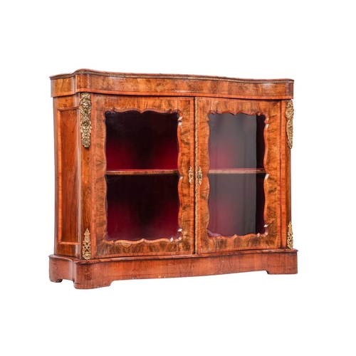 70 - A Victorian figured walnut serpentine chiffonier, fitted a pair of shaped and glazed doors, with gil... 