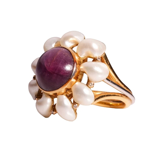 101 - A star sapphire and pearl dress ring in 18ct gold, centred with a collet-set round star sapphire of ... 