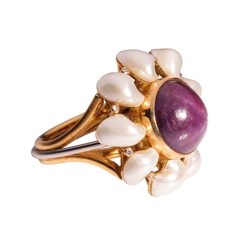 101 - A star sapphire and pearl dress ring in 18ct gold, centred with a collet-set round star sapphire of ... 