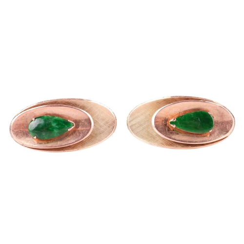 3 - A pair of jadeite-set cufflinks, the textured concave oval panels, each centred with a pear-shaped j... 