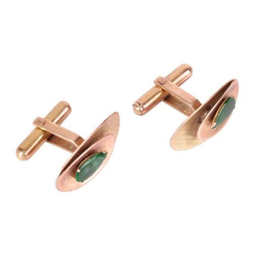 3 - A pair of jadeite-set cufflinks, the textured concave oval panels, each centred with a pear-shaped j... 