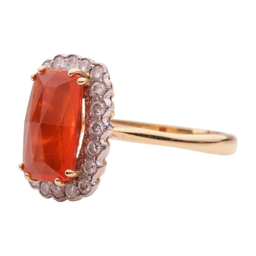 4 - A fire opal and diamond halo ring in 18ct gold, featuring an elongated cushion-shaped fire opal of 1... 