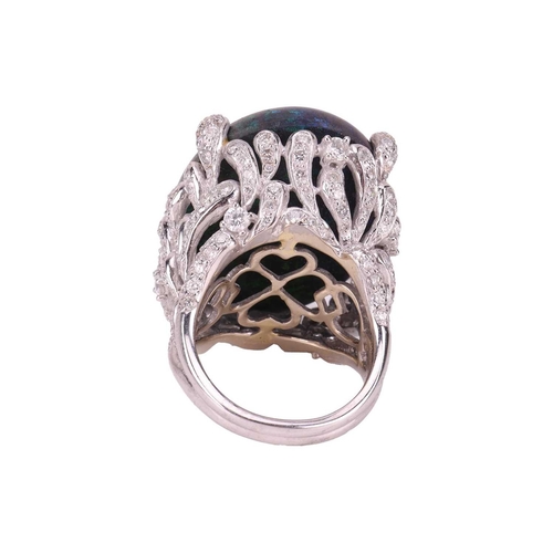 73 - A large black opal and diamond cocktail ring, featuring an oval cabochon of a black opal of 31.0 x 2... 