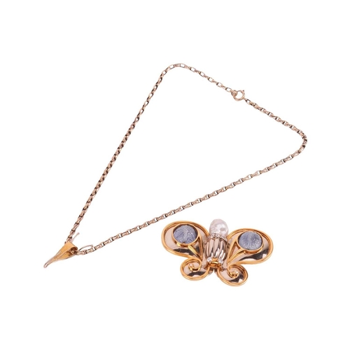 74 - A gem-set butterfly brooch in 18ct gold, the stylised butterfly with scrolled wings featuring two ca... 