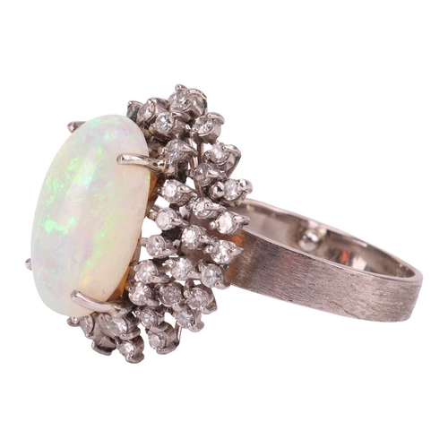 90 - An opal and diamond cluster ring, centred with an oval cabochon precious opal, displaying vibrant sp... 