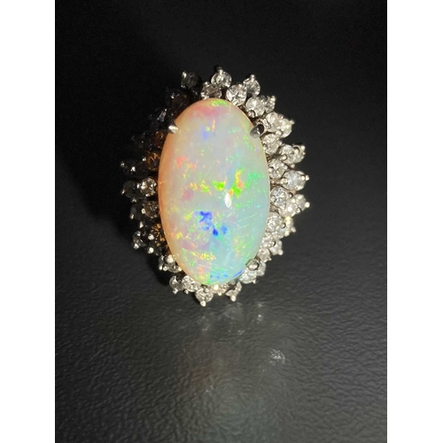 90 - An opal and diamond cluster ring, centred with an oval cabochon precious opal, displaying vibrant sp... 