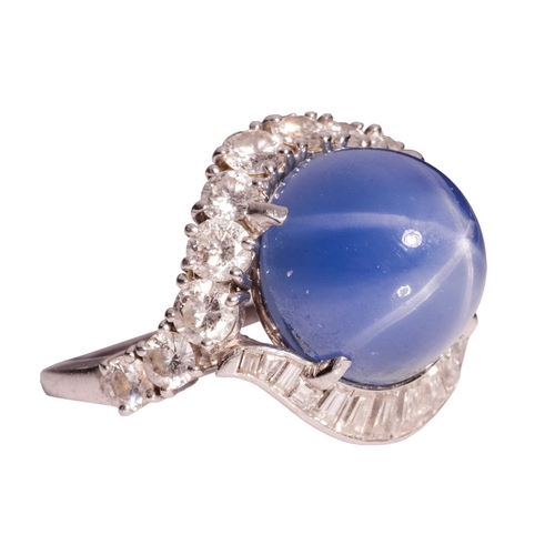 94 - A star sapphire and diamond cluster ring, comprising a claw-set high domed sapphire cabochon of medi... 