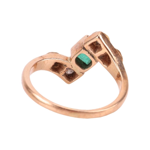 46 - An emerald and diamond crossover ring, centred with a square table-cut emerald in collet, between by... 