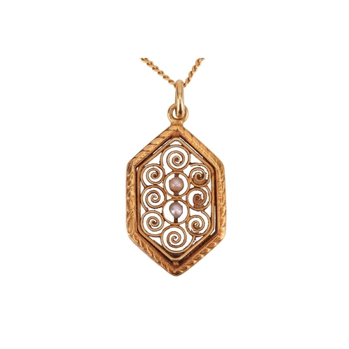 91 - A filigree pendant, the six-sided panel featuring filigree detailing of spiral design, centrally set... 