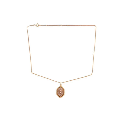 91 - A filigree pendant, the six-sided panel featuring filigree detailing of spiral design, centrally set... 
