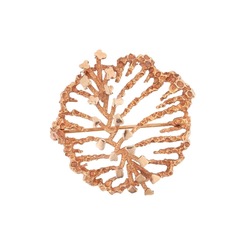58 - An abstract brooch in 9ct yellow gold, the organically textured mount adorned with a spine of polish... 