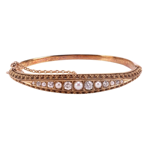 6 - A Victorian diamond and pearl-set hinged bangle, with one half of Etruscan revival design, centrally... 
