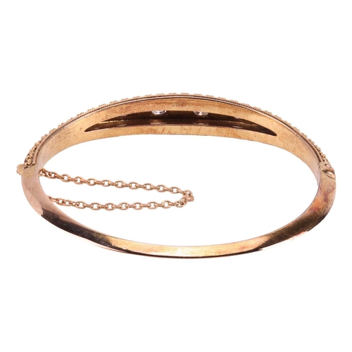 6 - A Victorian diamond and pearl-set hinged bangle, with one half of Etruscan revival design, centrally... 