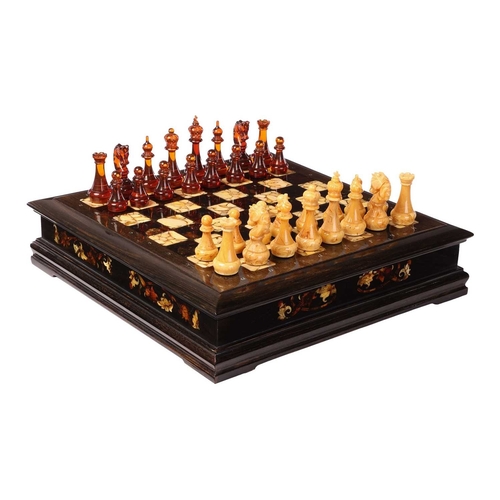 187 - A simulated amber chess set, late 20th century, the figures contained in a hardwood case with presse... 