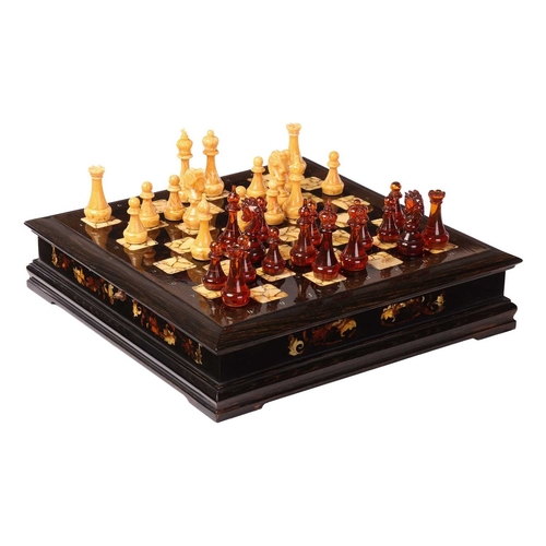 187 - A simulated amber chess set, late 20th century, the figures contained in a hardwood case with presse... 
