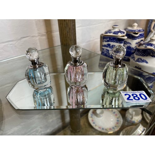 280 - 3 Perfume bottles on glass stand