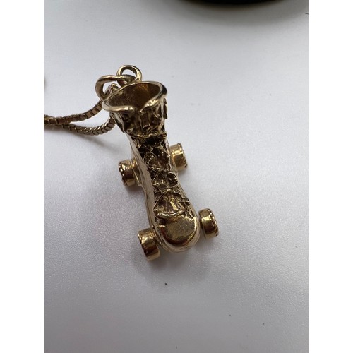 309 - 9ct Gold roller skate pendant on chain 15