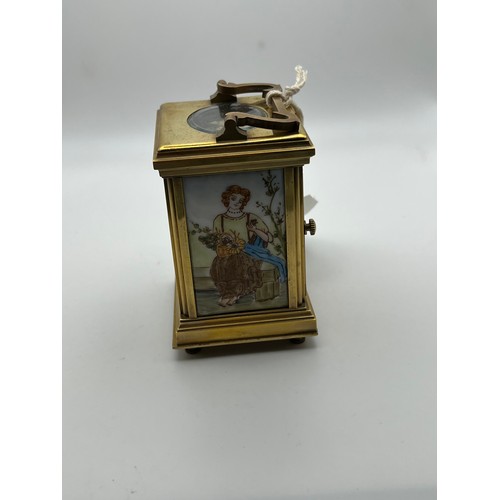 390 - Small brass carriage clock & key with picture enamel design on front & sides working