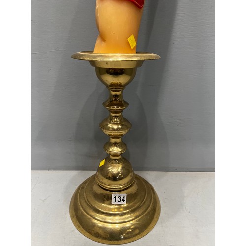134 - Brass candle stick with large candle dated 1983