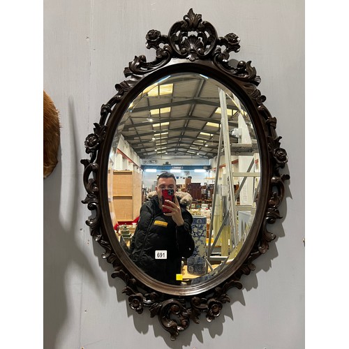 691 - Beautiful oval mirror set in carved ornate mahogany frame