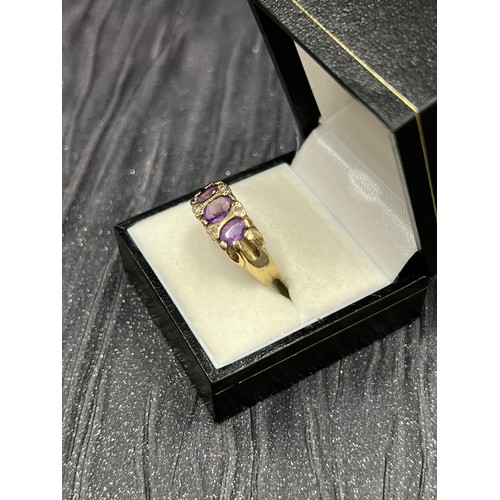 504 - 9ct gold trilogy purple stone ring.
Size N/O. 4g gross weight