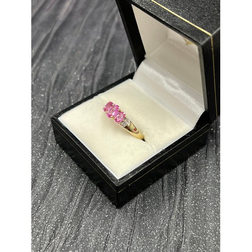 512 - 9ct gold trilogy ring with pink stones Size P. 2g total weight