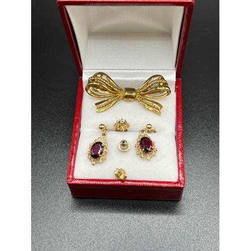 557 - 9ct Gold brooch + pair 9ct gold garnet earrings + 1 other 9ct earring 5.5g gross