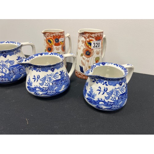 320 - 3 Graduated 'willow pattern' jugs + 2 Victorian jugs