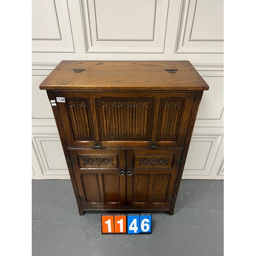 1146 - Oak linen fold fronted cocktail cabinet inserted with leather