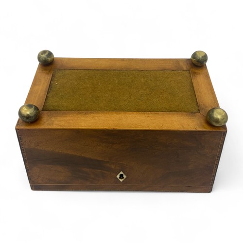 218 - A late Regency cross banded sarcophogus shaped tea caddy. Each of the panels is edged with four colo... 