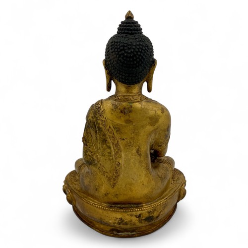 252 - A mid-20thC Nepalese gilt-patinated and aged hollow cast bronze Buddha in bhumisparsha mudra on a lo... 